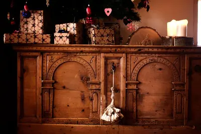 an old wooden cabinet with christmas decorations on it at Hotel Costabella in Passo San Pellegrino