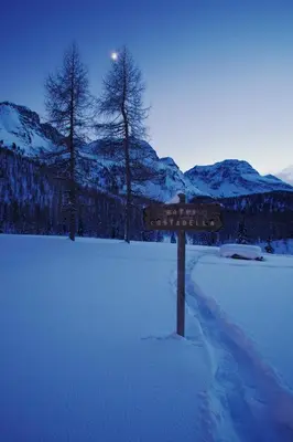 a sign in the middle of a snow covered field at Hotel Costabella in Passo San Pellegrino