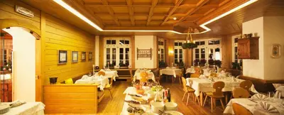 a dining room with white tables and chairs and tablesearcher at Hotel Costabella in Passo San Pellegrino