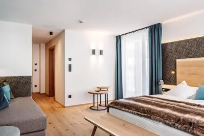 a hotel room with a bed and a table at Turmchalet Adults Only in Braies