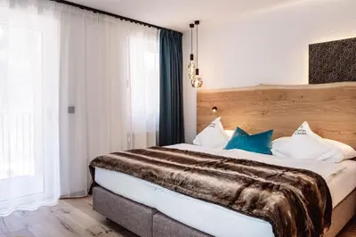 a bedroom with a large bed with blue pillows at Turmchalet Adults Only in Braies