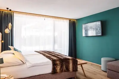 a bedroom with a bed with a large window at Turmchalet Adults Only in Braies