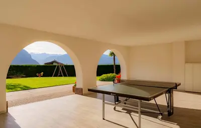 a ping pong table in a room with a view of a garden at Ferienwohnungen Wieserhof in Andrian in Andrian
