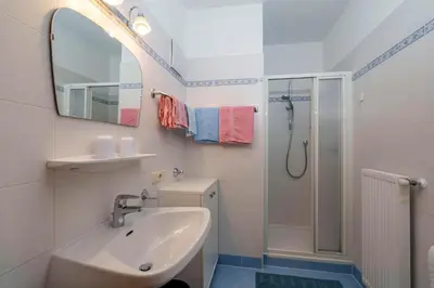 a white bathroom with a sink and a shower at Ferienwohnungen Wieserhof in Andrian in Andrian