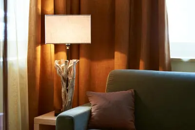 a lamp sitting on a table next to a couch at Color Home Suite Apartments in Predazzo