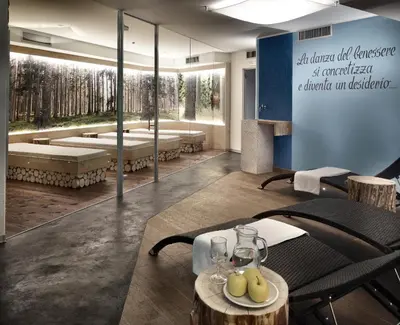 a dining room with a table and chairs and a wall at Color Home Suite Apartments in Predazzo