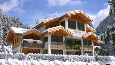 a house covered in snow with a fence at Color Home Suite Apartments in Predazzo