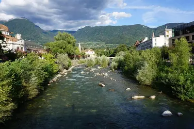 a river with rocks in the middle of a city at Living Apartment Central in Merano