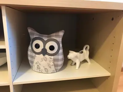 a owl pillow and a cat on a shelf at Living Apartment Central in Merano