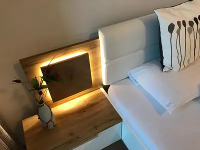 a bed with a light on the side of it at Living Apartment Central in Merano