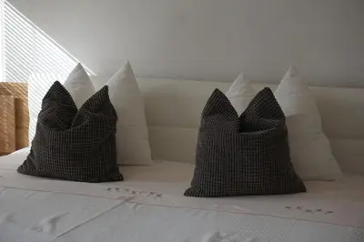two black and white pillows sitting on a bed at Living Apartment Central in Merano