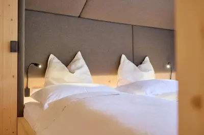 a bedroom with two beds with white sheets and pillows at Kircherhof in Bressanone