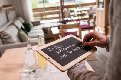 a person holding a book with a sign on it at Kircherhof in Bressanone