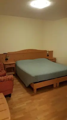 a bedroom with a bed and a table and a chair at Affittacamere Villa Belfiore in Ronzone