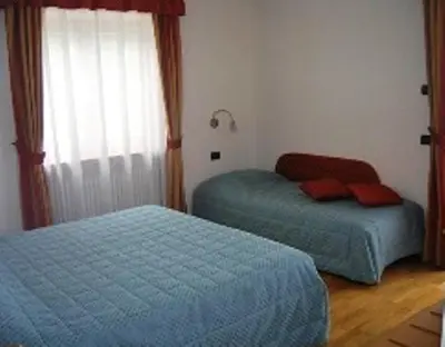 a bedroom with two beds and a window at Affittacamere Villa Belfiore in Ronzone