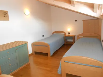a bedroom with two beds and a dresser at Affittacamere Villa Belfiore in Ronzone