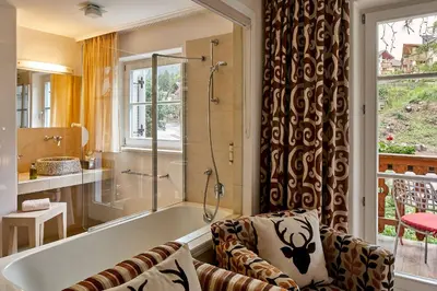 a bathroom with a bath tub and a shower at Dolomit Boutique Hotel in La Villa