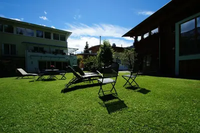 a group of chairs sitting on the grass in a yard at Dolomit Boutique Hotel in La Villa