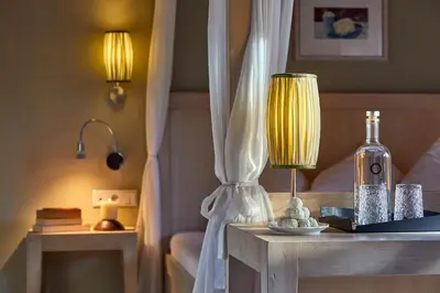a bedroom with a bed and a table with a lamp at Dolomit Boutique Hotel in La Villa