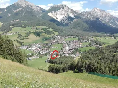 a town in the middle of a valley with mountains at Alfred Ties Apartments in San Vigilio Di Marebbe
