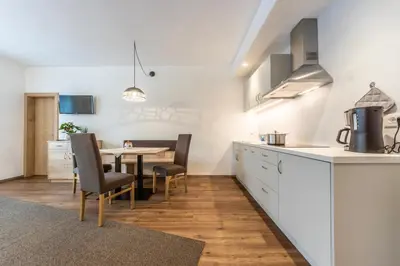 a kitchen and dining room with a table and chairs at Alfred Ties Apartments in San Vigilio Di Marebbe