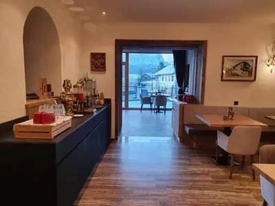 a restaurant with a counter and a dining room with a view at Hotel Andechserhof & Mountain Sky in Laion