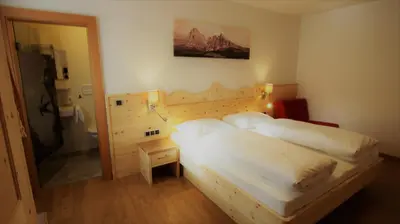 a hotel room with two beds and a bathroom at Hotel Andechserhof & Mountain Sky in Laion