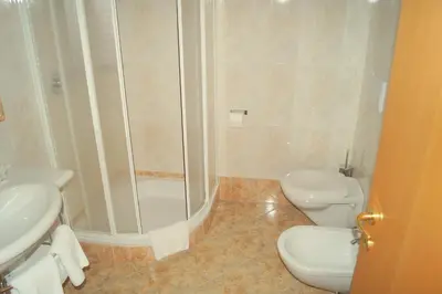 a bathroom with a shower and a toilet and a sink at Hotel Andechserhof & Mountain Sky in Laion