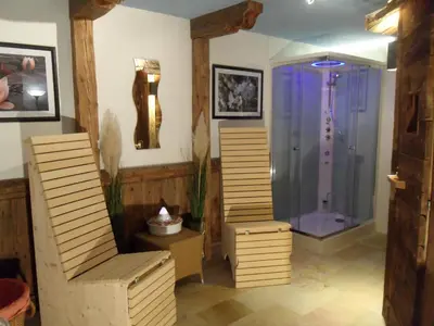 a room with a shower with a bench and a chair at Hotel FleurAlp in Cermes