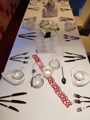a table with wine glasses and chopsticks and a necklace at Hotel FleurAlp in Cermes
