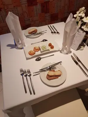 a white table with a plate of food on it at Hotel FleurAlp in Cermes