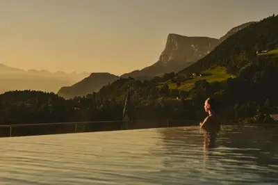 a woman standing in the water in the mountains at ALPIANA - green luxury Dolce Vita Hotel in Vollan
