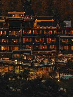 a building lit up at night with lights at ALPIANA - green luxury Dolce Vita Hotel in Vollan