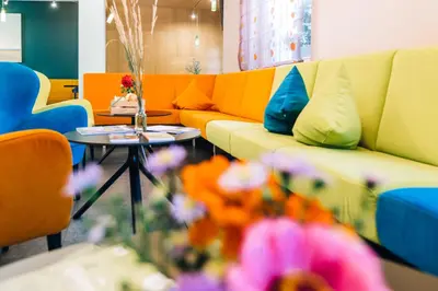 a living room with a couch and a table with flowers at Zum Löwen-Post in Trodena