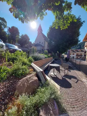 a bench and a table in a park at Zum Löwen-Post in Trodena