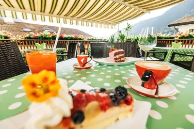 a table with a plate of food and drinks on it at Zum Löwen-Post in Trodena