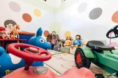 two children sitting in a play room with toys at Zum Löwen-Post in Trodena