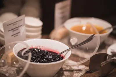 a table with bowls of food and a cup of tea at Emma Historic Hotel in Villabassa