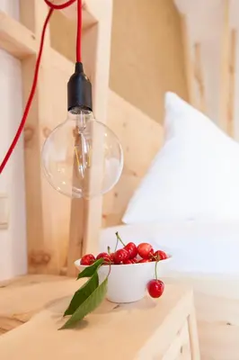 a light bulb and a bowl of cherries on a table at Hotel-Chalet Pennhof in Barbiano