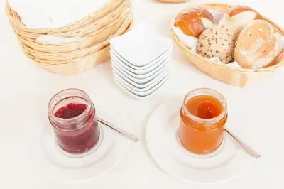 a white table with a plate of bread and a basket of bread at Hotel-Chalet Pennhof in Barbiano