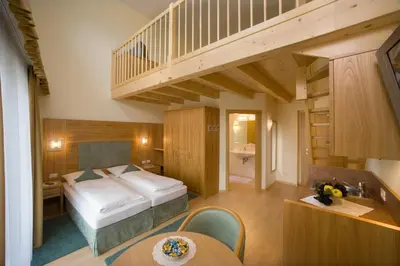 a hotel room with a bed and a staircase at Hotel Förstlerhof in Postal