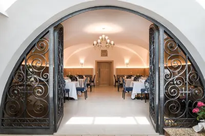 a dining room with tables and a chandelier at Hotel Förstlerhof in Postal