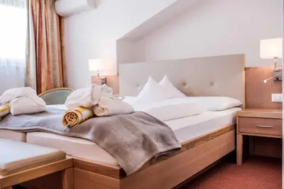 a bedroom with a bed with towels on it at Hotel Förstlerhof in Postal