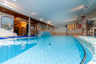 a large indoor swimming pool with blue tiles at Pension Kofler in Vollan