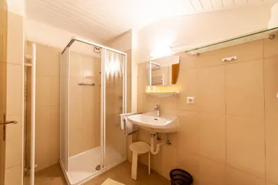 a bathroom with a sink and a shower at Pension Kofler in Vollan