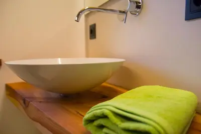 a bathroom with a bowl sink and a green towel at Rofenhof in Naturno