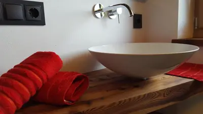 a bathroom with a white sink and a red towel at Rofenhof in Naturno