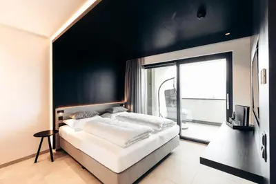 a bedroom with a bed and a large window at Villa Weingarten in Caldaro
