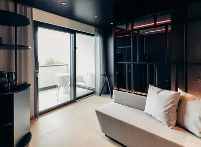 a living room with a couch and large windows at Villa Weingarten in Caldaro