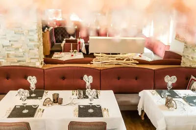 a dining room with two tables and a couch at Hotel Dorfer Alpine&Charming in Selva di Val Gardena